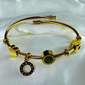 Gold stainless steel cable bracelet with green gemstone, waterproof